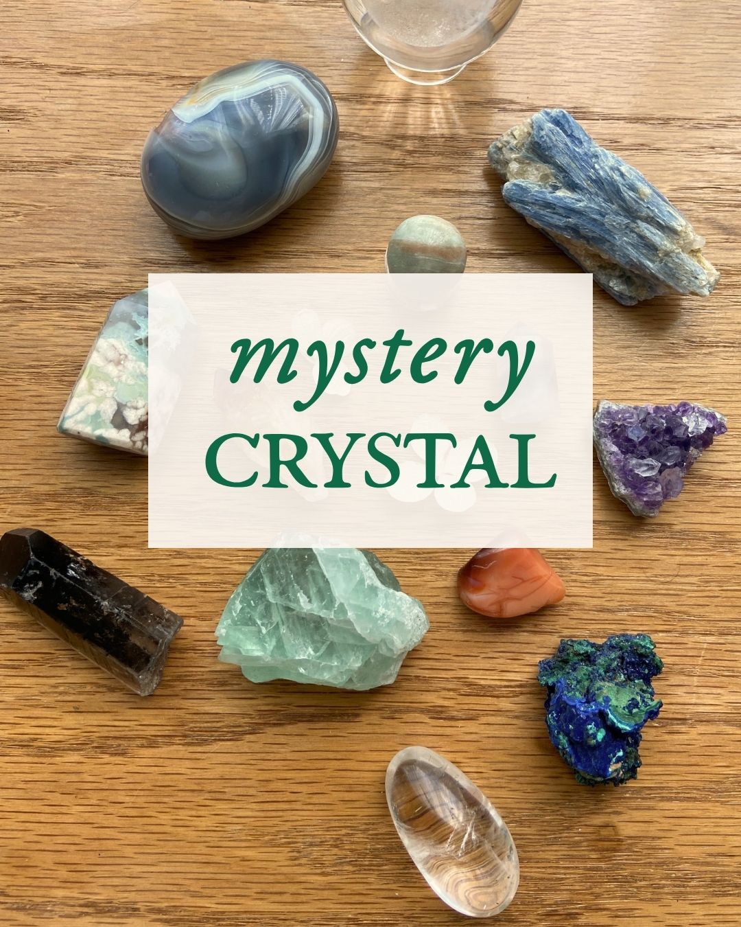 Collection of various crystals on a wooden surface with a 'mystery crystal' label.